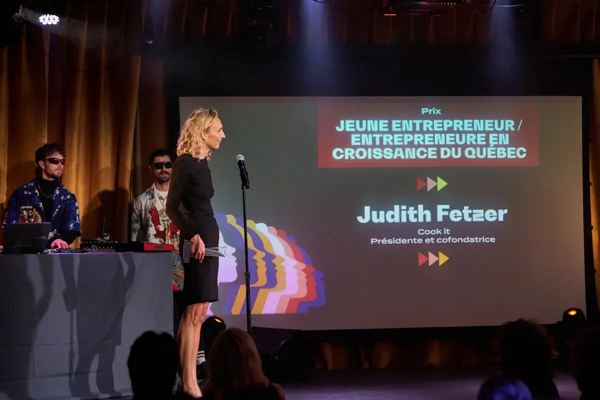 Judith Fetzer sur scène recevant un prix lors d'un gala, devant un écran affichant “Jeune entreprise en croissance” et son nom en tant que présidente et cofondatrice de Cook it