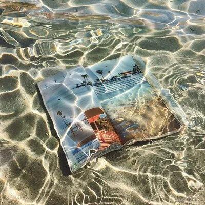 Magazine ouvert posé sur le sable